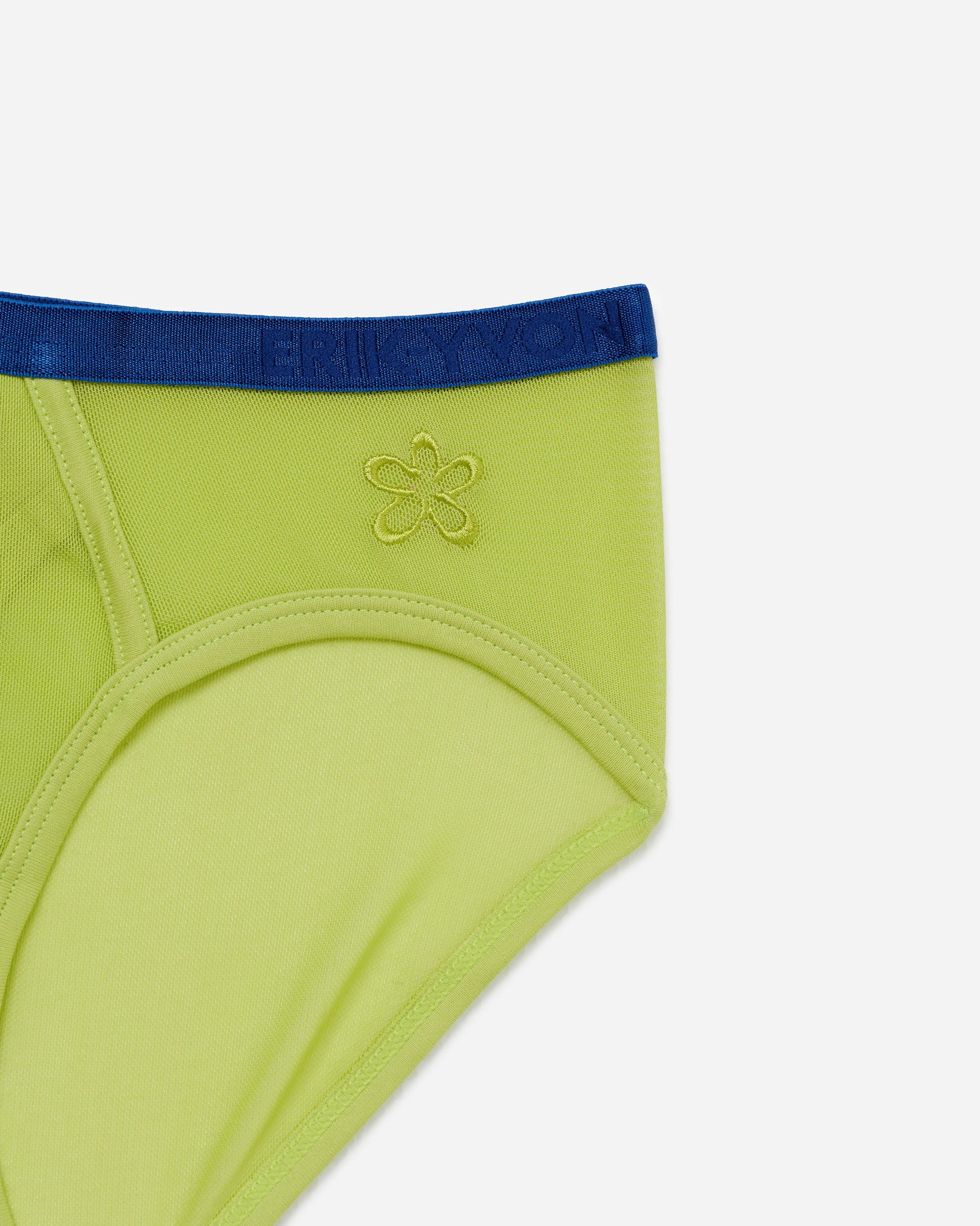 Close-up of a bright lime green pair of mesh briefs with a navy blue waistband and a small gold embroidered flower logo on the front, set against a plain light gray background.