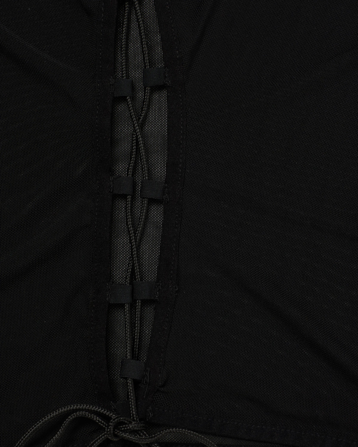 Close-up detail of a black lace-up mesh top.